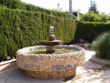 jardin con fuente y estanque peces