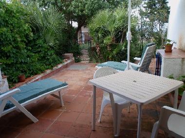 jardn decorado con sillas, mesa, tumbona, sombrilla,
