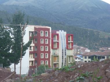 Es el edificio izquierdo, el segundo balcon de arriba